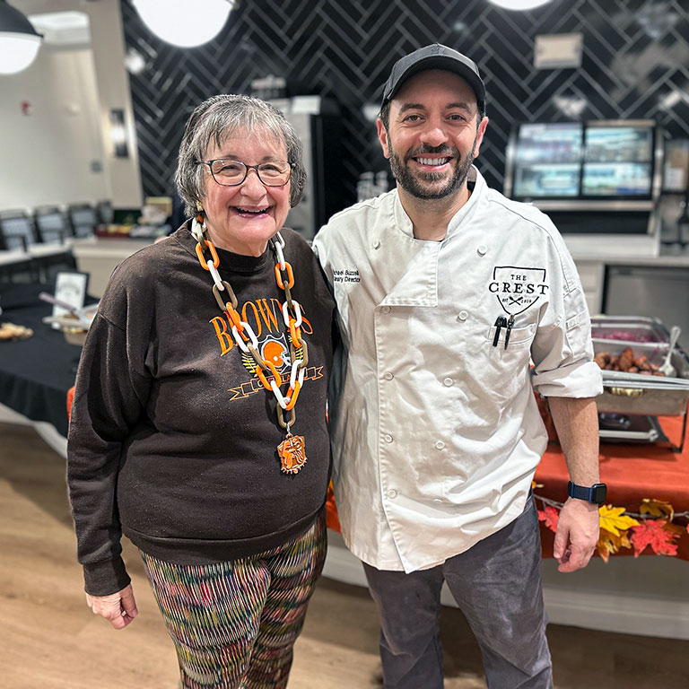 A culinary team member and senior woman smile together at Vitalia Montrose.