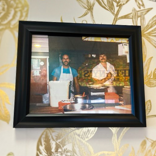 A photo on the wall of Tiffany's Bakery, featuring family in decades past, mixing up treats at the establishment.