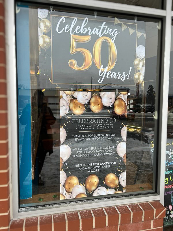 Window sign commemorating the 50th anniversary for Tiffany's Bakery.